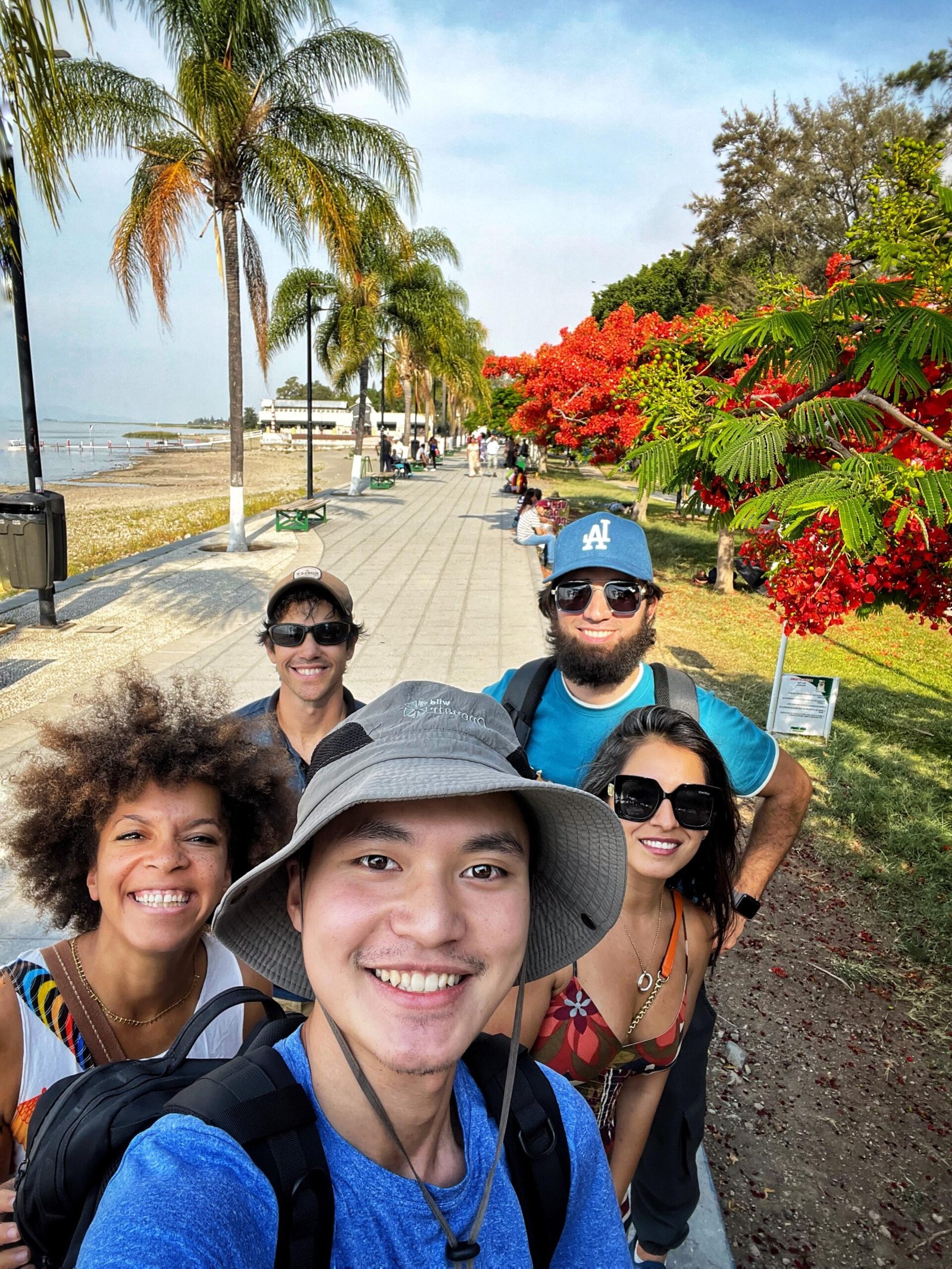 Grupo de amigos sonríen en un paseo arbolado.