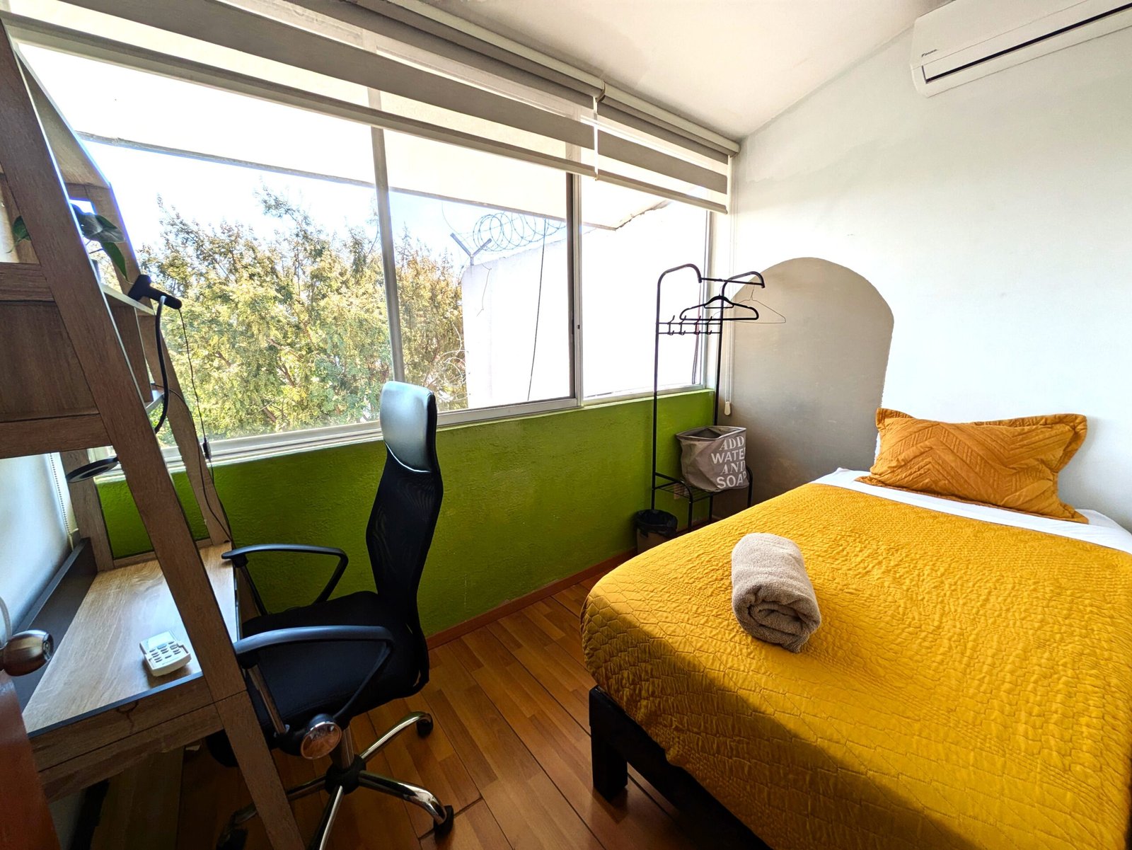 Habitación luminosa con cama y escritorio.