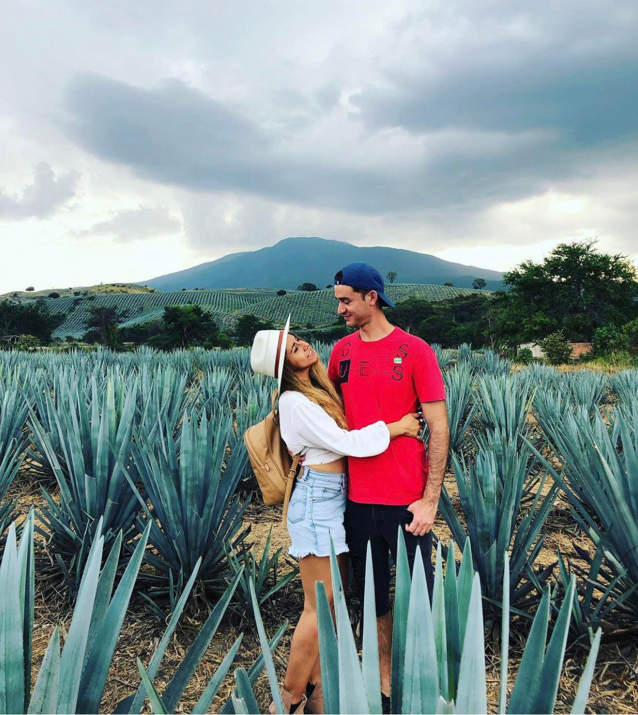 Pareja abrazada en plantación de agave.