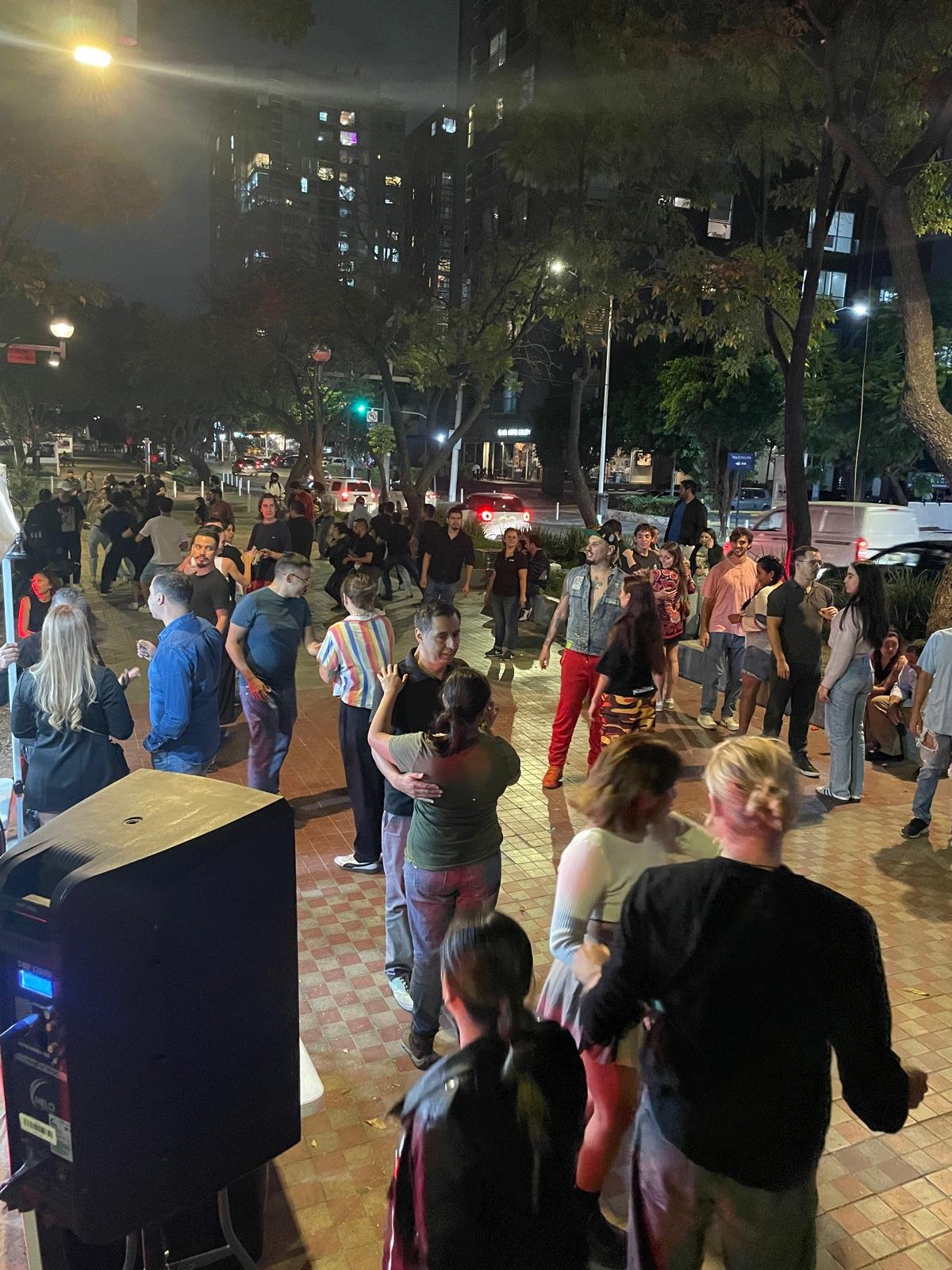 Personas bailando al aire libre por la noche.