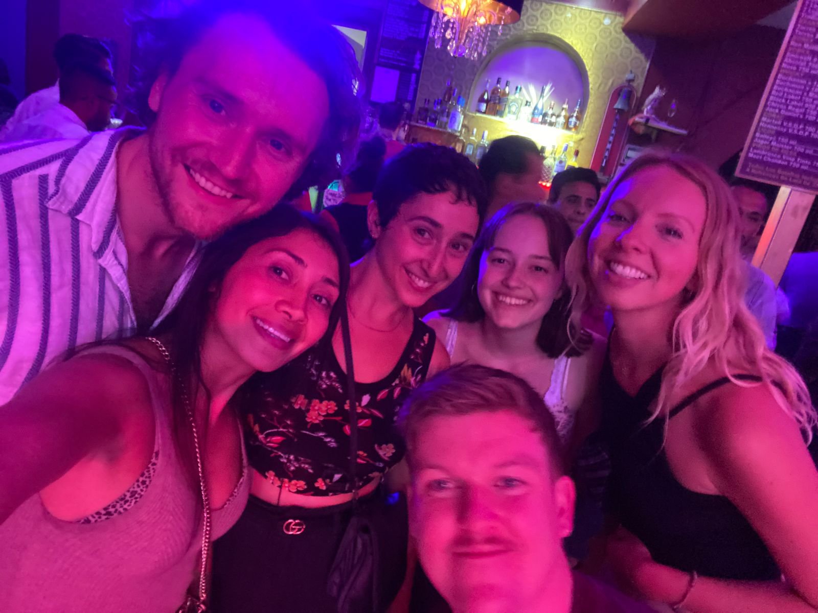 Grupo de amigos sonrientes en un bar iluminado.