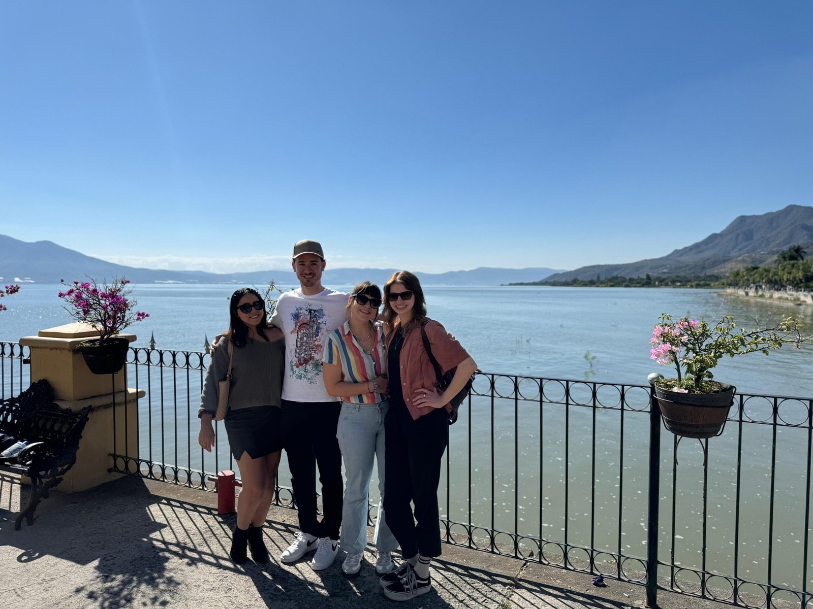 Grupo de amigos posando junto a un lago.