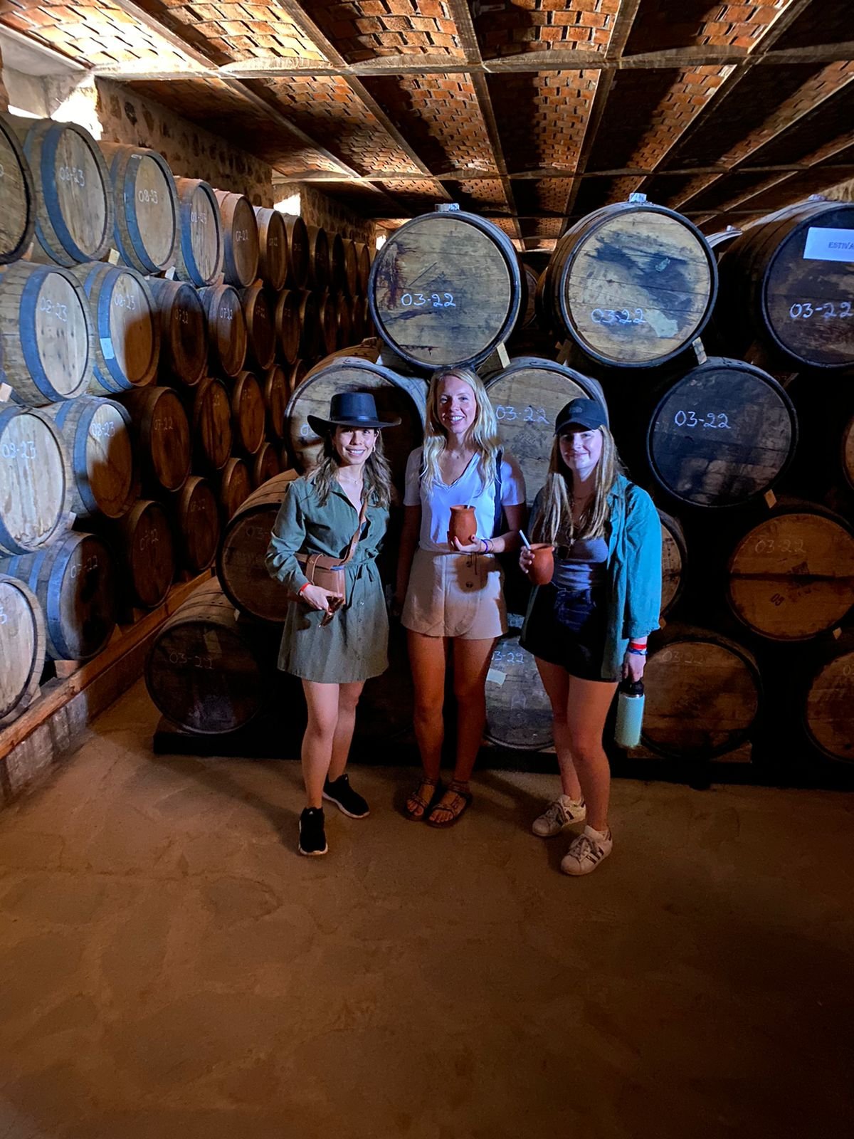 Personas en bodega de barriles de madera.