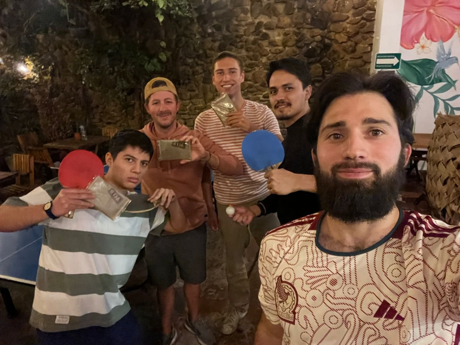 Grupos de amigos jugando ping pong en restaurante mexicano.