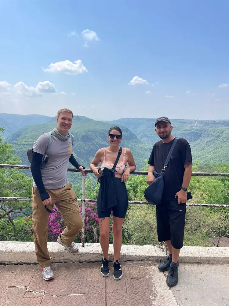 Personas posando en mirador con vista de montañas.