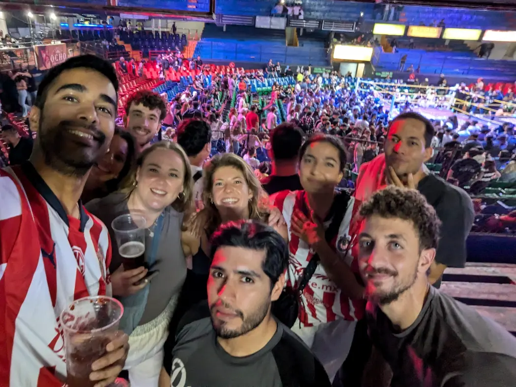 Amigos en evento deportivo, estadio lleno.