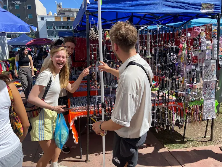 Amigos comprando en un mercado de artesanías al aire libre.