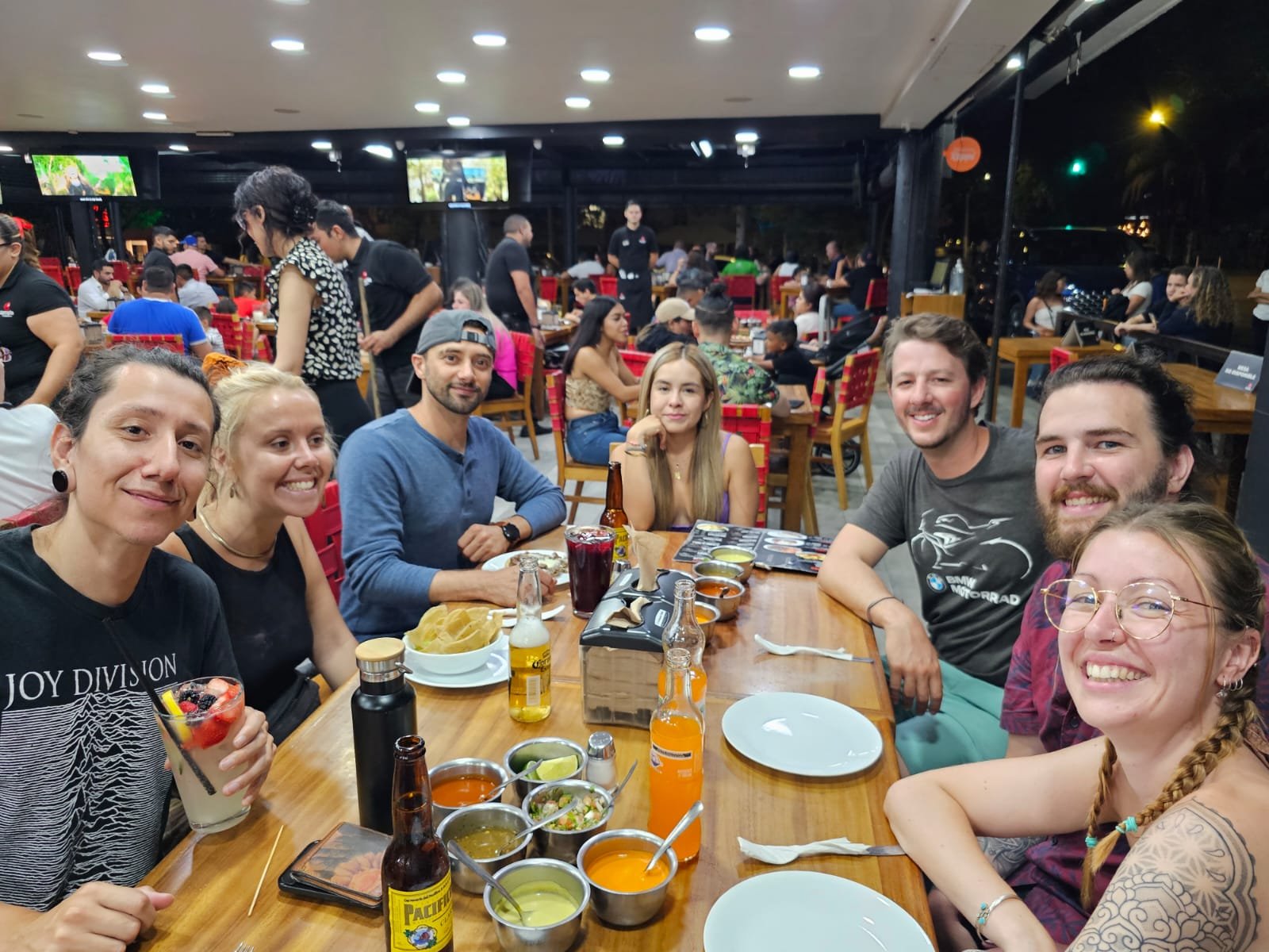 Grupo de amigos cenando en un restaurante animado.