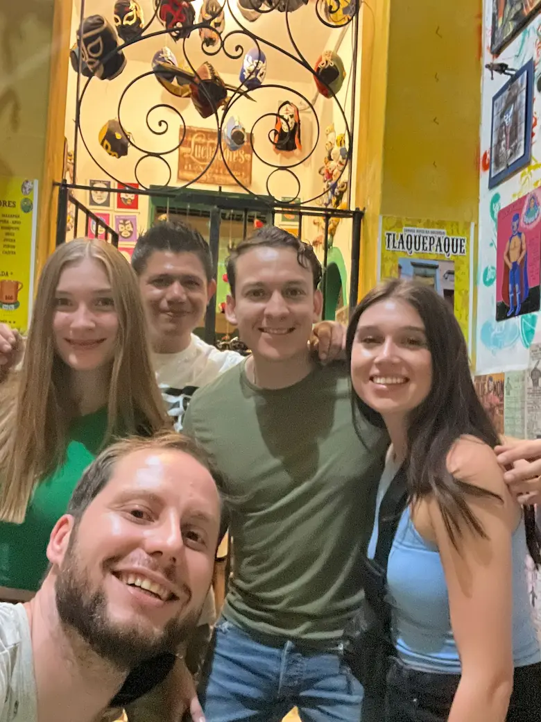 Grupo de amigos sonríe frente a tienda mexicana.