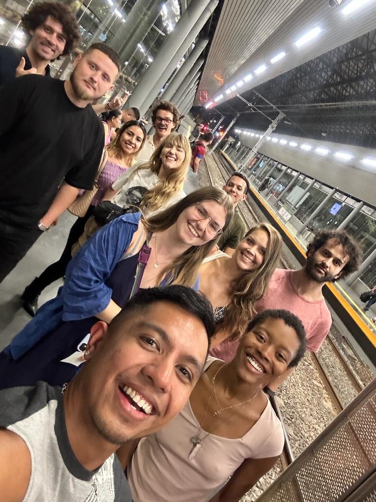 Grupo de amigos sonríe en la estación del tren.