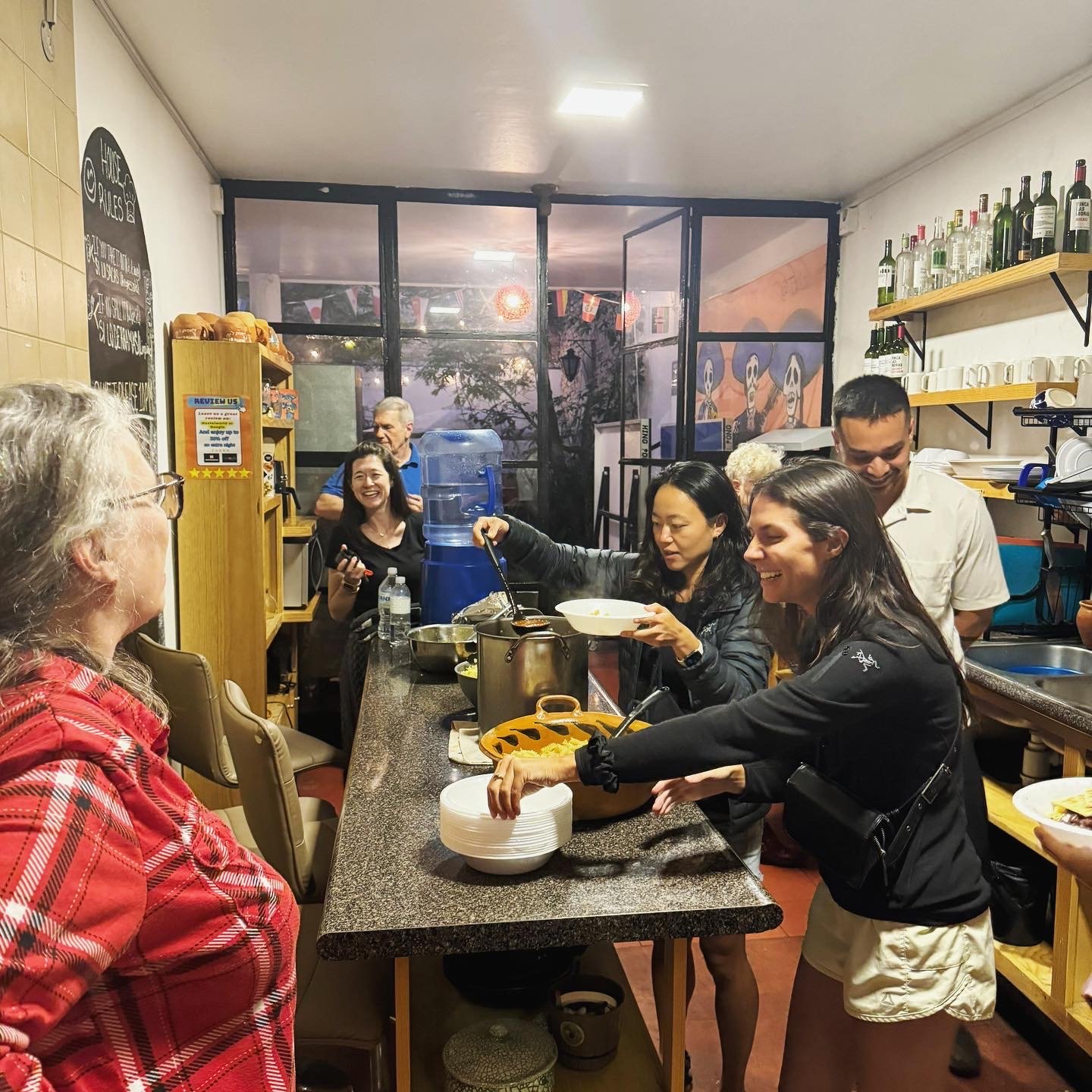 Personas sirviéndose comida en cocina comunitaria.