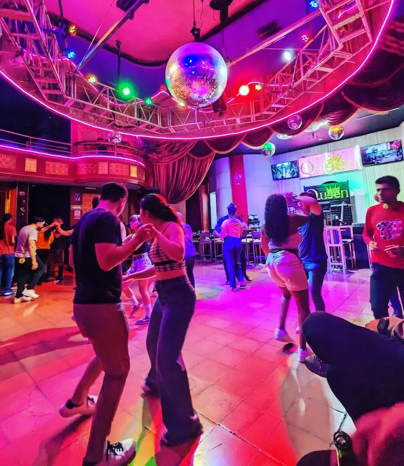 Personas bailando en un club nocturno iluminado
