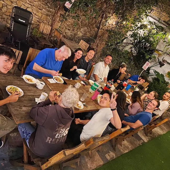 Grupo de personas cenando al aire libre.